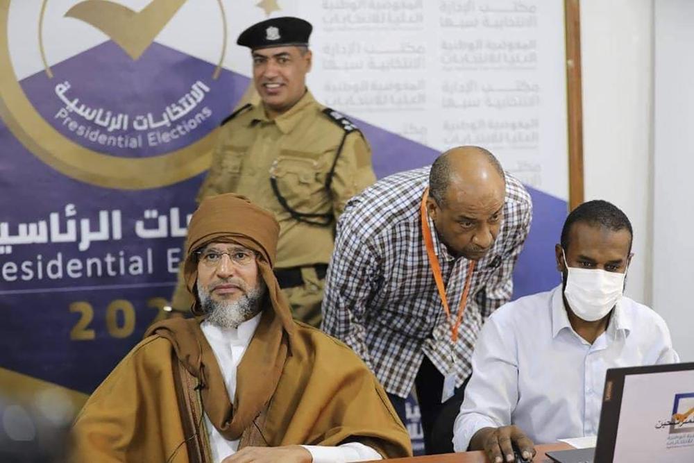 Seif al-Islam, left, the son and one-time heir apparent of late Libyan dictator Moammar Gadhafi registers his candidacy for the country’s presidential elections next month, in Sabha, Libya, Sunday, Nov. 14, 2021. Al-Islam, who was seen as the reformist face of Gadhafi's regime before the 2011 uprising, was released in June 2017 after more than five years of detention. (Libyan High National Elections Commission via AP)