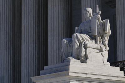 Esta foto del 21 de febrero del 2022 muestra la estatua "The Authority of Law", de James Earle Fraser, a la entrada del edificio de la Corte Suprema de Estados Unidos.  (AP Foto/Patrick Semansky)