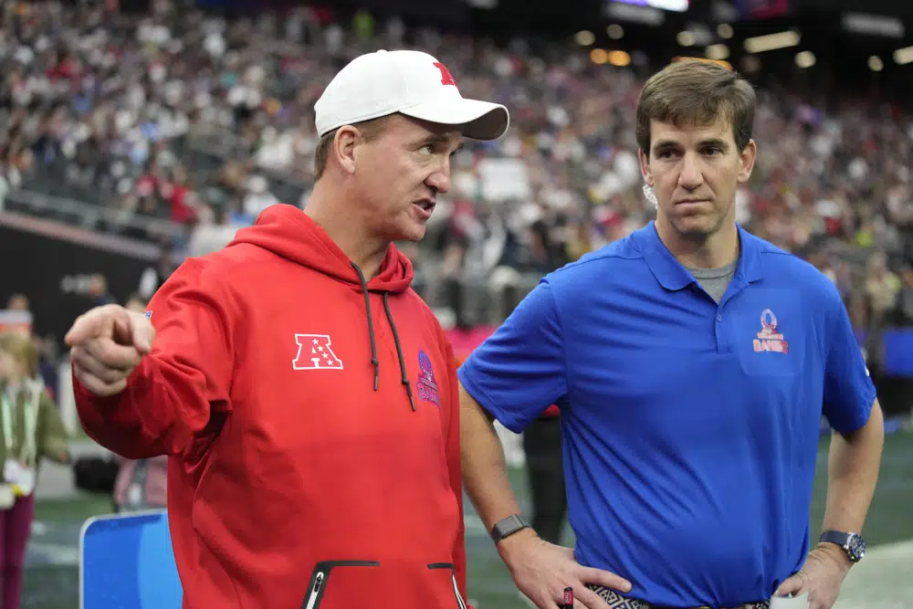AFC coach Peyton Manning, left, talks with NFC coach Eli Manning during the flag football event at the NFL Pro Bowl, Sunday, Feb. 5, 2023, in Las Vegas. (AP Photo/John Locher)