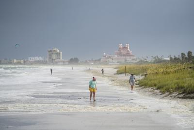 Unas personas caminan por la playa Pass-a-Grille tras el paso de la tormenta Elsa en Tampa Bay, Florida, el 7 de julio de 2021. (Martha Asencio-Rhine/Tampa Bay Times via AP)