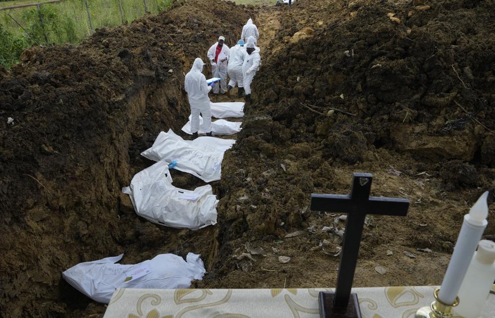 Un equipo forense entierra a un grupo de migrantes que murieron tratando de cruzar la peligrosa jungla del Darién, en el cementerio de Guayabillo en Agua Fría, Panamá, el jueves 30 de septiembre de 2021. (Foto AP/Arnulfo Franco)