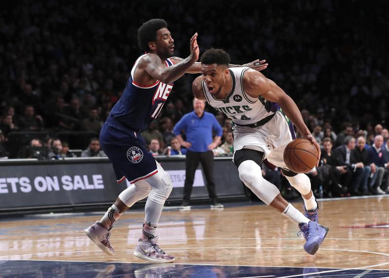 Milwaukee Bucks forward Giannis Antetokounmpo (34) drives to the basket against Brooklyn Nets guard Kyrie Irving (11) during the first half of an NBA basketball game Thursday, March 31, 2022, in New York. (AP Photo/Noah K. Murray)