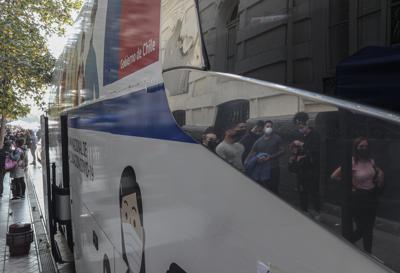 Personas se reflejan en el recorte de un autobús utilizado como centro de vacunación COVID-19, mientras hacen fila para ser vacunados en Santiago, Chile, el lunes 24 de mayo de 2021. (AP Foto/Esteban Felix)