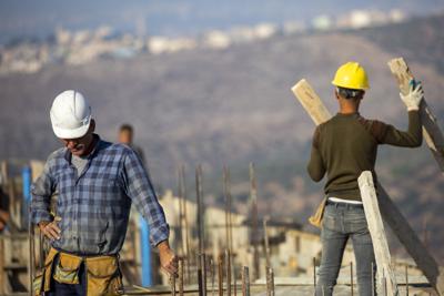 Palestinos construyen viviendas nuevas en el asentamiento judío de Bruchin, en Cisjordania, cerca del poblado palestino de Nablus, el lunes 25 de octubre de 2021. (AP Foto/Ariel Schalit)