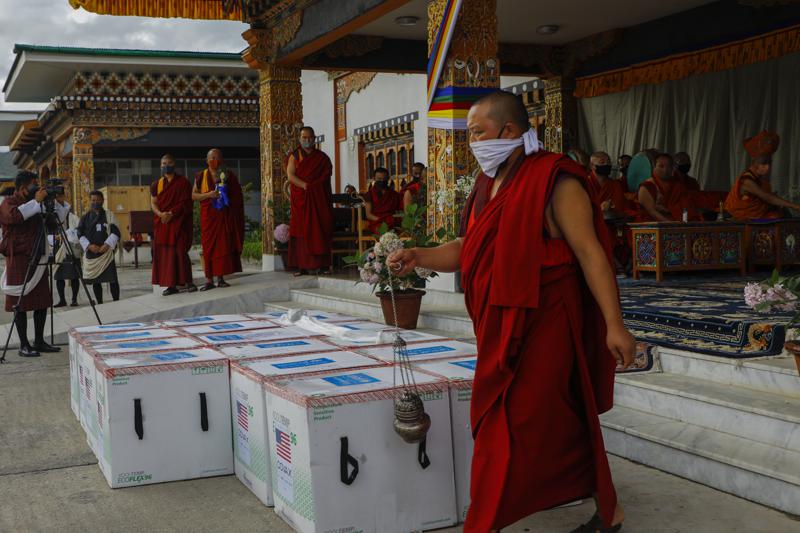 This photograph provided by UNICEF shows monks from Paro's monastic body perform a ritual as 500,000 doses of Moderna COVID-19 vaccine gifted from the United States arrived at Paro International Airport in Bhutan, July 12, 2021. The Himalayan kingdom of Bhutan has fully vaccinated 90% of its eligible adult population within just seven days, its health ministry said Tuesday. (UNICEF via AP)