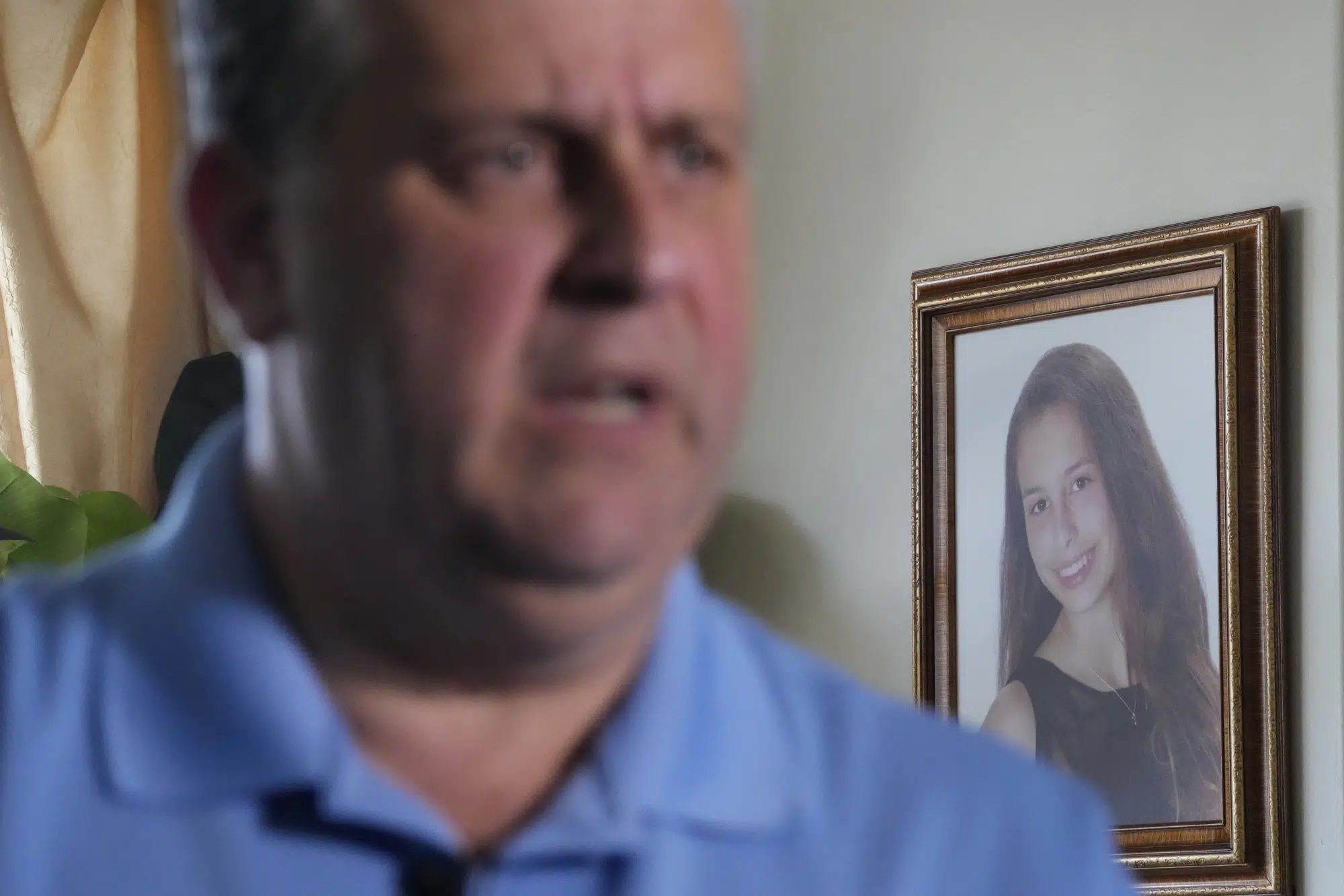 A portrait of Gina Rose Montalto hangs in the family home as her father, Tony Montalto, speaks during an interview, Friday, Feb. 3, 2023, in Parkland, Fla. Gina was one of the victims of Parkland's Marjory Stoneman Douglas High School shooting five years ago. Her parents, Tony and Jennifer, set up the Gina Rose Montalto Memorial Foundation, to help dozens of college students and others. (AP Photo/Wilfredo Lee)