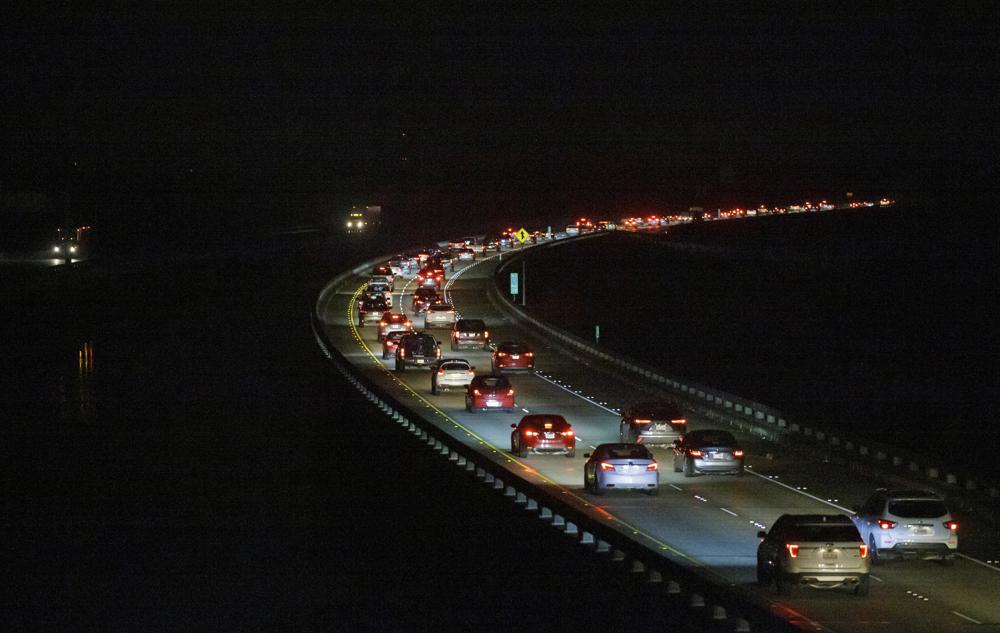 Westbound I-10 traffic on the Bonnet Carré Spillway is slow going at 4:00 a.m. near Kenner, La. Saturday, Aug. 28, 2021, as many New Orleans area residents evacuate ahead of Hurricane Ida.   Residents across Louisiana’s coast are taking one last day to prepare for what is being described as a “life-altering” Hurricane Ida. The storm is expected to bring winds as high as 140 mph (225 kph) when it slams ashore.  (David Grunfeld, NOLA.com/The Times-Picayune/The New Orleans Advocate  via AP)