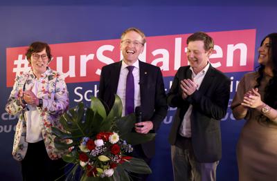 Daniel Günther de la Unión Demócrata Cristiana, ministro presidente del estado de Schleswig-Holstein y principal candidato de su partido, segundo de izquierda a derecha, sonríe después de que se dieran a conocer las primeras proyecciones de las elecciones estatales en Schleswig-Holstein, el domingo 8 de mayo de 2022, en Kiel, Alemania. (Christian Charisius/dpa vía AP)