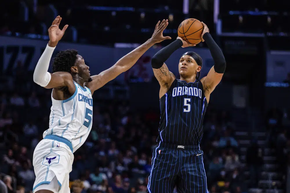 Orlando Magic forward Paolo Banchero, right, attempts a jump shot over Charlotte Hornets center Mark Williams, left, during the second half of an NBA basketball game Friday, March 3, 2023, in Charlotte, N.C. (AP Photo/Scott Kinser)