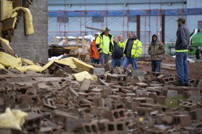 Empleados de Stewart Richey Electrical y otros trabajadores despejan escombros en Thornton Furniture el sábado 1 de enero de 2022, en Bowling Green, Kentucky, tras otro aviso de posible tornado. (Grace Ramey/Daily News vía AP)