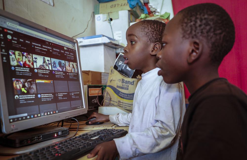 Two young boys use a computer at an internet cafe in the low-income Kibera neighborhood of Nairobi, Kenya Wednesday, Sept. 29, 2021. Instead of serving Africa's internet development, millions of internet addresses reserved for Africa have been waylaid, some fraudulently, including in insider machinations linked to a former top employee of the nonprofit that assigns the continent's addresses. (AP Photo/Brian Inganga)