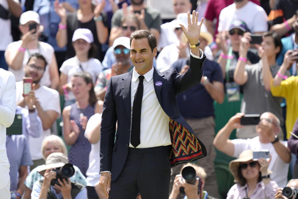 Roger Federer saluda durante el festejo del centenario de la Cancha Central de Wimbledon, el domingo 3 de julio de 2022. (AP Foto/Kirsty Wigglesworth)