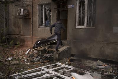Un hombre ingresa a su edificio incendiado luego de un ataque ruso, el domingo 17 de abril de 2022, en Járkiv, Ucrania. (AP Foto/Felipe Dana)
