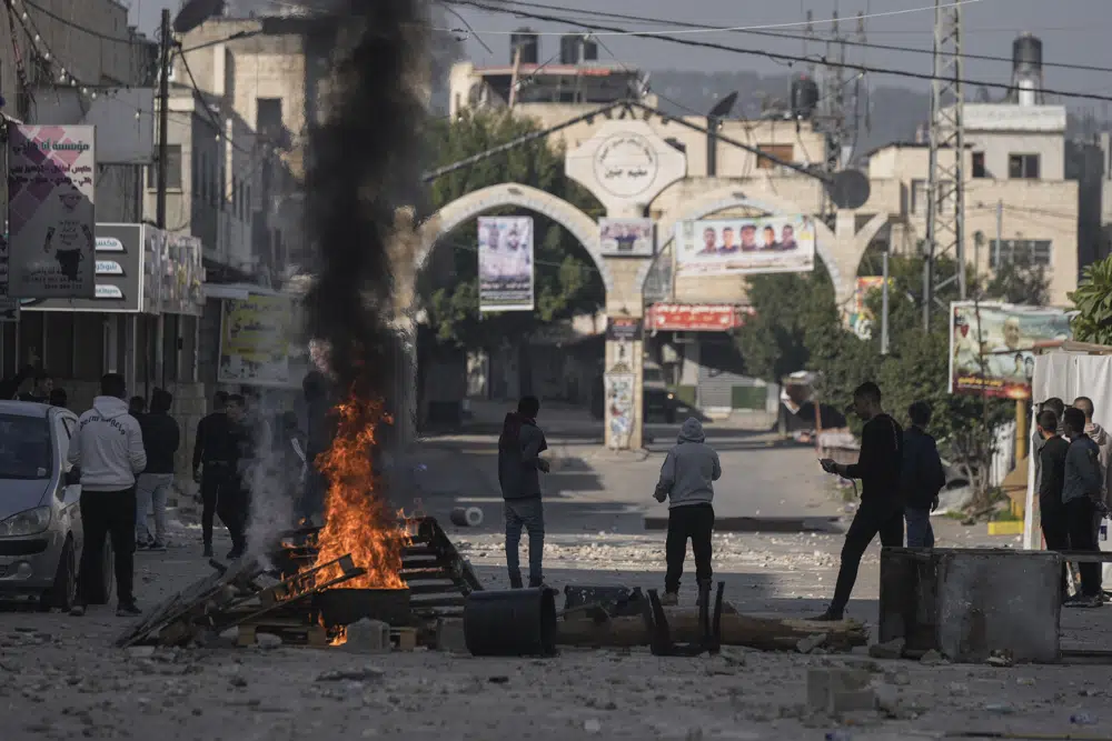 Palestinians clash with Israeli forces following an army raid in the West Bank city of Jenin, Thursday, Jan. 26, 2023. Israeli forces killed at least nine Palestinians, including a 60-year-old woman, and wounded several others during a raid in a flashpoint area of the occupied West Bank on Thursday, Palestinian health officials said, in one of the deadliest days in months of unrest. The Israeli military said it was conducting an operation to arrest a militant grouping linked to the Palestinian Islamic Jihad, which has major foothold in the camp. A gun battle erupted, during which the military said it was targeting militants involved in planning and carrying out attacks on Israelis. (AP Photo/Majdi Mohammed)