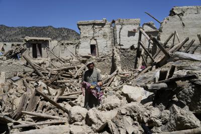 Un hombre lleva en brazos a su hijo entre los escombros luego de un terremoto en Gayan, en la provincia de Paktika, Afganistán, el 24 de junio del 2022. (AP Foto/Ebrahim Nooroozi)