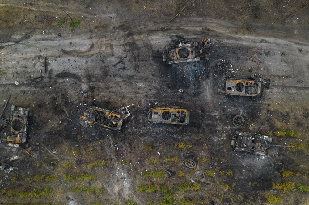 FILE - Destroyed Russian armored vehicles sit on the outskirts of Kyiv, Ukraine, March 31, 2022. In the year since Russia invaded Ukraine, disinformation and propaganda have emerged as key weapons in the Kremlin's arsenal. (AP Photo/Rodrigo Abd, File)