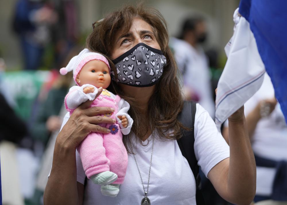 Un activista contra el aborto sostiene una muñeca durante una protesta frente a la Corte Constitucional mientras los jueces continúan las discusiones sobre la despenalización del aborto en Bogotá, Colombia, el lunes 21 de febrero de 2022. (AP Foto/Fernando Vergara)