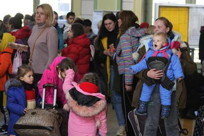 Ukrainian Marina Stadnik from Kramatosrk, right, arrives with her four children at a train station in Przemysl, southeastern Poland, Monday, March 28, 2022. The more than month-old war has killed thousands and driven more than 10 million Ukrainians from their homes — including almost 4 million from their country. (AP Photo/Sergei Grits)