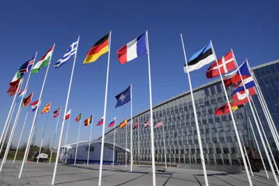Un poste vacío se ve entre las banderas nacionales de Francia y Estonia ante la sede de la OTAN en Bruselas, el lunes 3 de abril de 2023. El martes por la tarde se celebrará una ceremonia en la sede de la OTAN para añadir la bandera finlandesa a las de otros miembros del grupo. (AP Foto/Virginia Mayo)