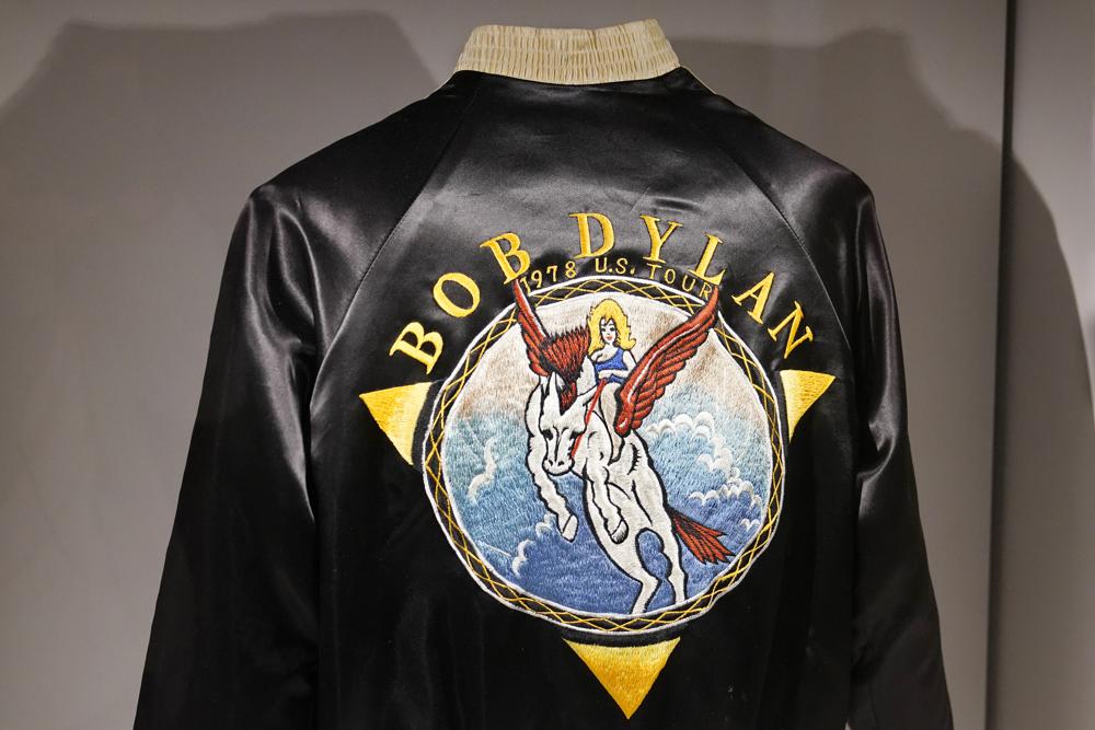 Una chaqueta de la gira de 1978 se exhibe en el Bob Dylan Center, el jueves 5 de mayo de 2022, en Tulsa, Oklahoma. El jueves, 5 de mayo de 2022, en Tulsa, Oklahoma. El centro ofrece una experiencia cinematográfica inmersiva, un espacio de actuación, un estudio donde los visitantes pueden jugar al productor y "mezclar" diferentes elementos de instrumentación en las canciones de Dylan y un recorrido curado donde las personas pueden hacer un viaje musical a través de las etapas de su carrera.  (Foto AP/Sue Ogrocki)