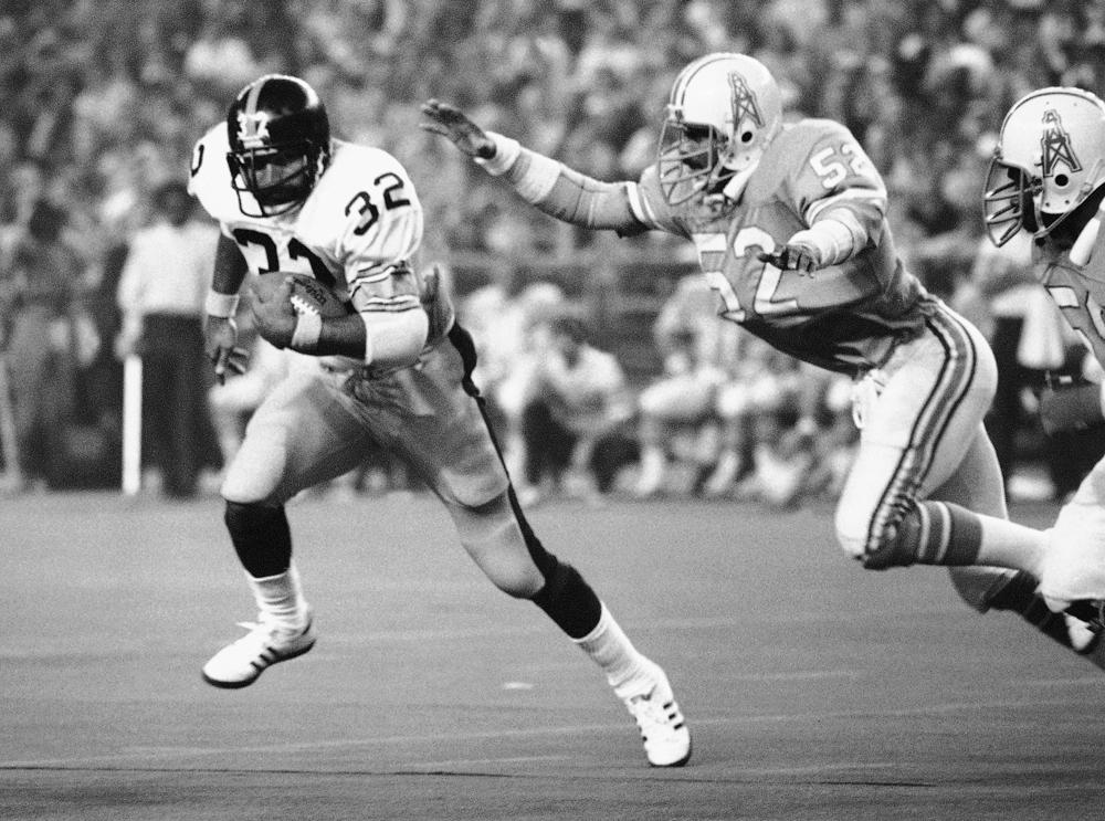 FILE - Pittsburgh Steelers running back Franco Harris (32) picks up 10 yards as he turns the corner as Houston Oilers' Robert Brazile (52) tries to make a dive to latch on to Harris to make the stop, during an NFL football game in Houston on Dec. 3, 1978. Harris died on Wednesday morning, Dec. 21, 2022, at age 72, just two days before the 50th anniversary of The Immaculate Reception. (AP Photo/Ed Kolenovsky, File)