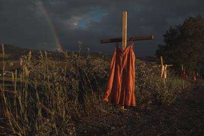 Esta imagen, distribuida por World Press Photo, fue elegida por el concurso como Imagen del Año, fue tomada por Amber Bracken para The New York Times. Titulada Internado Kamloops, muestra vestidos rojos colgados de cruces a lo largo de una carretera para recordar a los niños que murieron en el internado Kamloops, una institución creada para asimilar a niños indígenas, tras el hallazgo de 215 fosas en Kamloops, Columbia Británica, el 19 de junio de 2021. (Amber Bracken para The New York Times/World Press Photo vía AP)