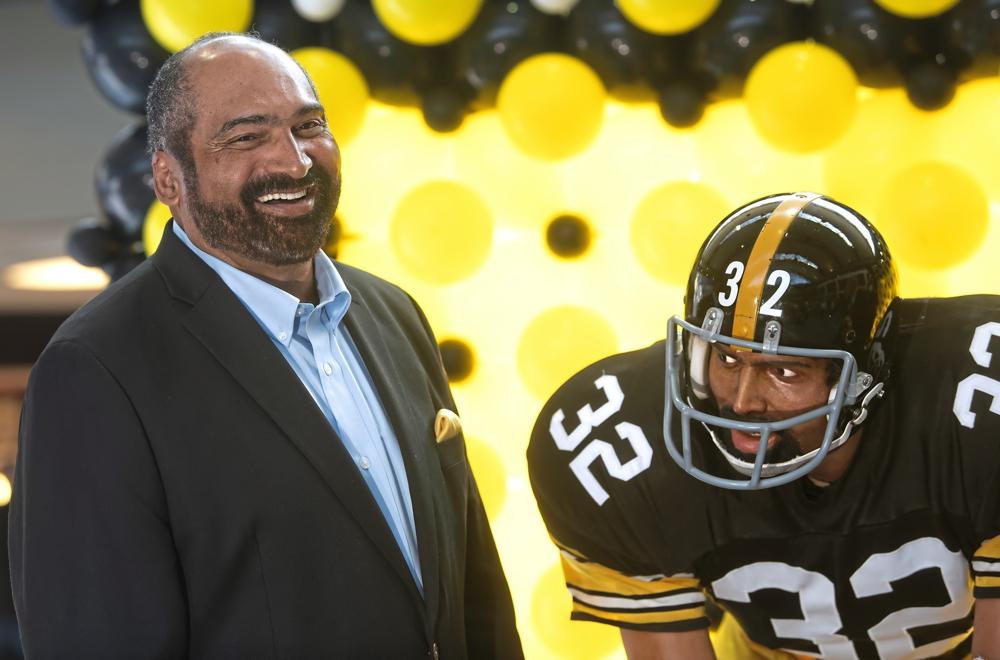 FILE - Former Pittsburgh Steelers running back Franco Harris stands next a statute of himself on Sept. 12, 2019, at Pittsburgh International Airport near Pittsburgh. Harris died on Wednesday morning, Dec. 21, 2022, at age 72, just two days before the 50th anniversary of The Immaculate Reception. (Nate Guidry/Pittsburgh Post-Gazette via AP, File)