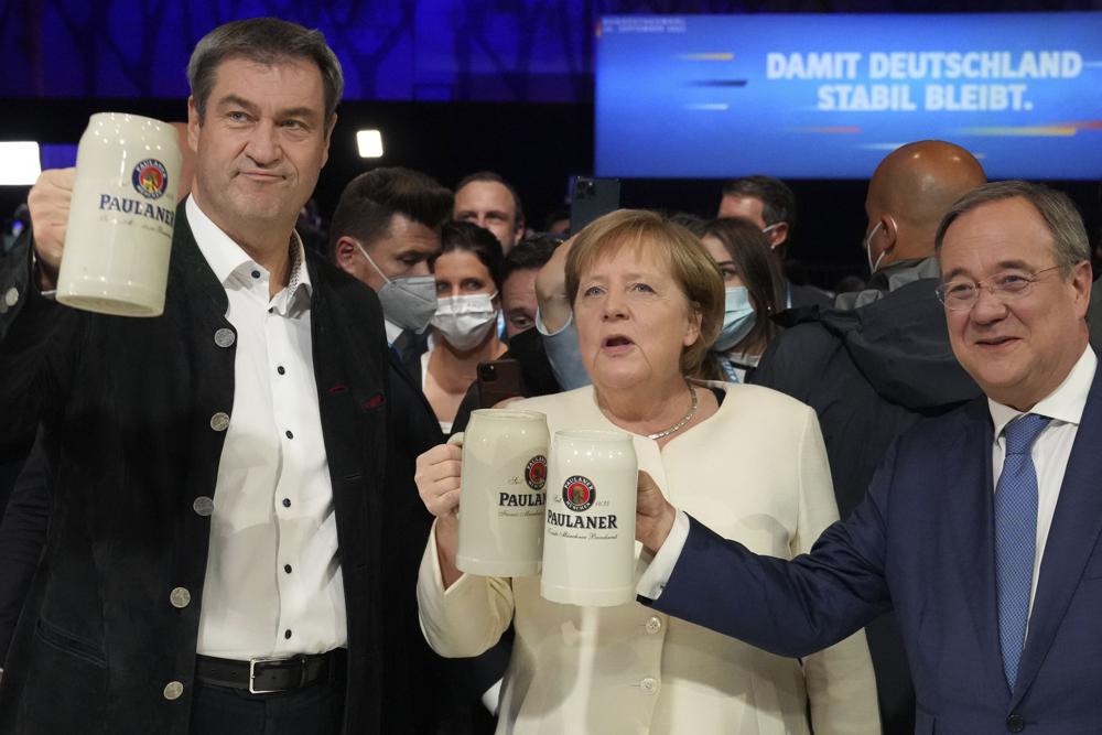 German chancellor Angela Merkel, Bavarian State Governor Markus Soeder, left, and Christian Democrats candidate Armin Laschet attend a state election campaign in Munich, Germany, Friday, Sept. 24, 2021 two days before the General election on Sunday, Sept. 26, 2021. (AP Photo/Matthias Schrader)