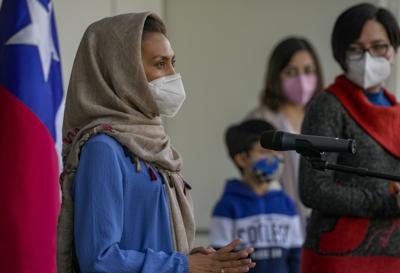 Zainab Momeny, quien era profesora universitaria en Afganistán, habla durante una conferencia de prensa mientras su hermana Zahar mira, a la derecha, poco después de aterrizar en el aeropuerto de Santiago, Chile, el viernes 10 de septiembre de 2021. (AP Foto/Esteban Félix)