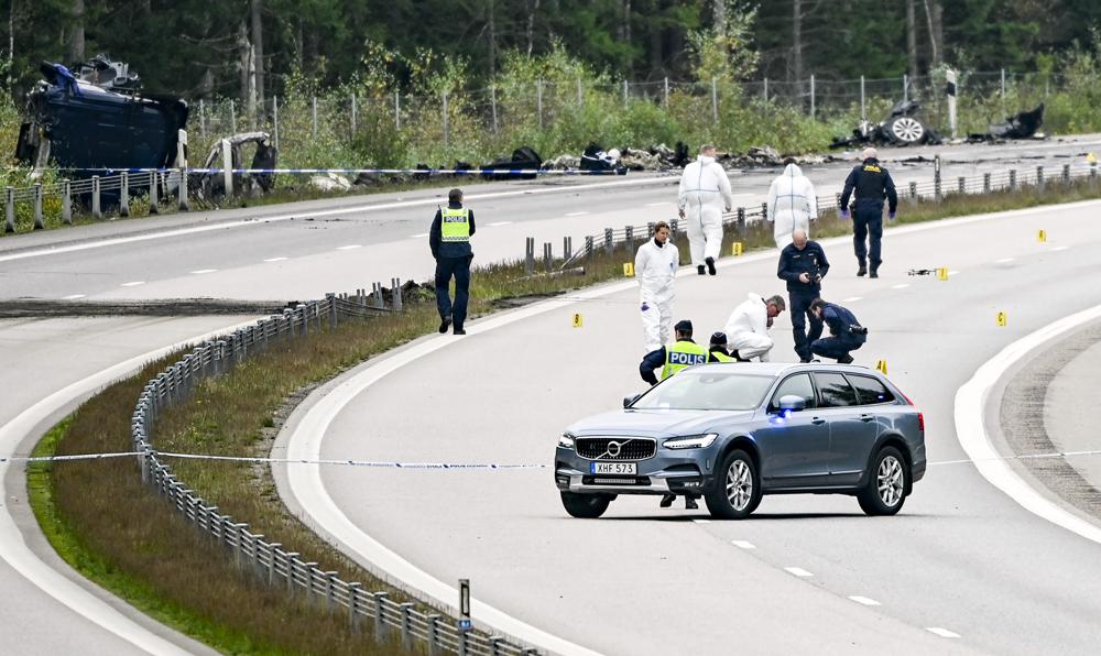 Forensic technicians work at the scene after a traffic accident between a car and a lorry outside the town Markaryd in Sweden, Monday Oct. 04, 2021. Three people died in the accident that took place on Sunday afternoon, one of whom was Swedish artist Lars Vilks. Carina Persson, police chief for southern Sweden, said Vilks and two plainclothes police bodyguards were killed in a head-on crash with a truck on Sunday. (Johan Nilsson/TT News Agency via AP)