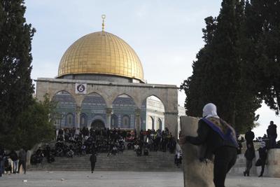 Un manifestante palestino se cobija detrás de un escudo improvisado durante choques con la policía israelí en el complejo de la mezquita de Al Aqsa, en la Ciudad Vieja de Jerusalén, el 22 de abril de 2022. (AP Foto/Mahmoud Illean)