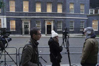 Periodistas reunidos ante el número 10 de Downing Street el martes 25 de enero de 2022, mientras el primer ministro británico, Boris Johnson, enfrenta nuevas acusaciones de haber incumplido las normas contra el coronavirus después de que su oficina reconociera que celebró un cumpleaños en la residencia oficial durante la primera cuarentena británica. (Stefan Rousseau/PA via AP)