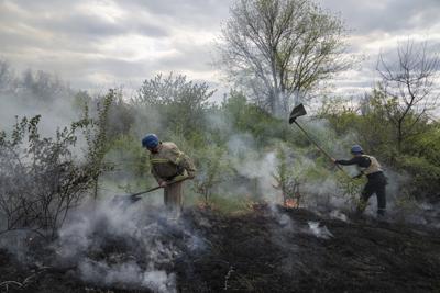 Rescatistas apagan un incendio en una zona de matorrales tras un ataque en Mykolaivka, en la región de Donetsk, en el este de Ucrania, el 29 de abril de 2022. (AP Foto/Evgeniy Maloletka)