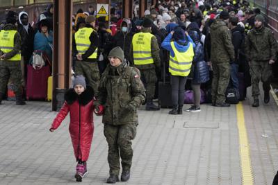 Un soldado acompaña a un niño en una estación de tren llena de refugiados provenientes de Ucrania, el 27 de febrero de 2022, en Przemysl, Polonia. (AP Foto/Czarek Sokolowski, archivo)