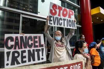 ARCHIVO – En esta fotografía de archivo del 4 de agosto de 2021, activistas protestan contra el fin de la moratoria a los desalojos en Nueva York. Las pancartas dicen “cancelen las rentas” y “paren los desahucios”. (AP Foto/Brittainy Newman, Archivo)