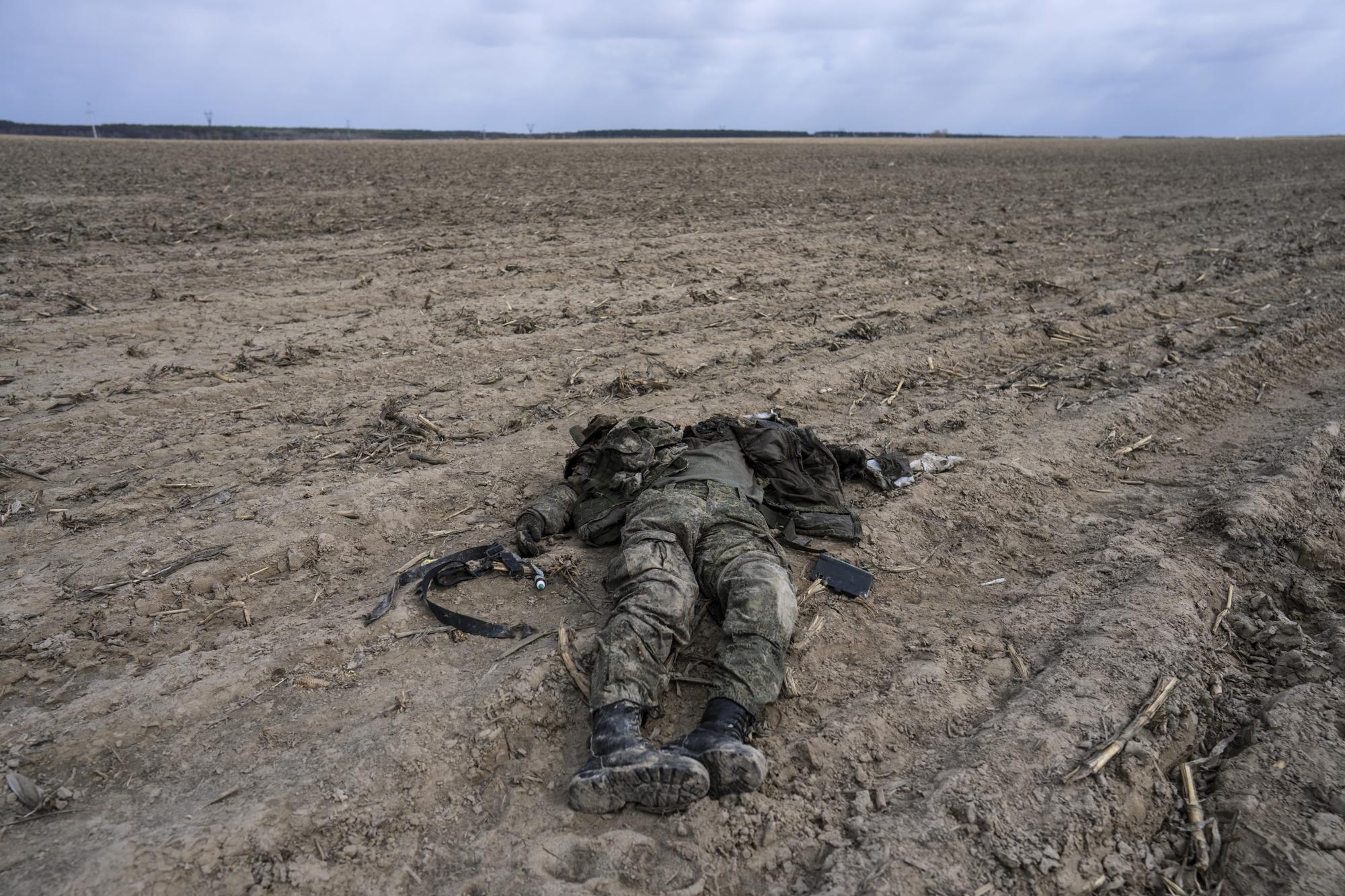 A Russian soldier killed during combats against the Ukrainian army lies in a corn field in Sytnyaky on the outskirts of Kyiv, Ukraine, Sunday, March 27, 2022. (AP Photo/Rodrigo Abd)