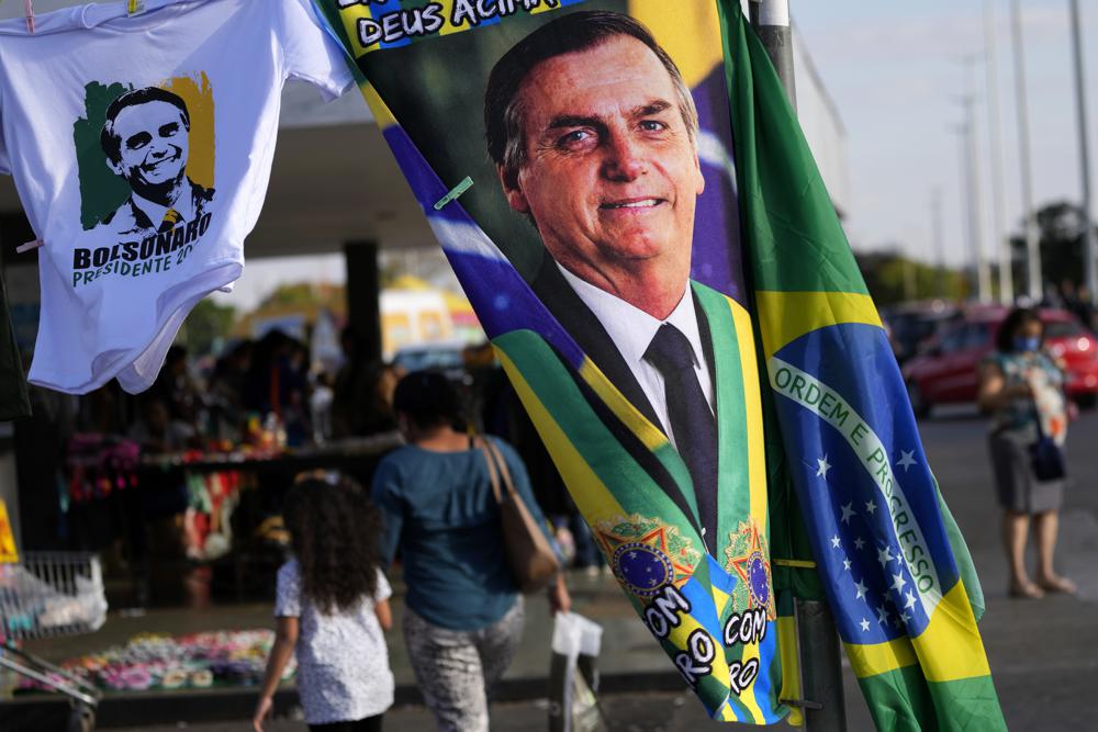 FILE - A banner emblazoned with an image of Brazil's President Jair Bolsonaro, who is a candidate for reelection, is displayed for sale in Brasilia, Brazil, Aug. 2, 2022.  Almost half a century later to the day, thousands are expected to rally on Aug. 11, for the readings of two documents inspired by the original “Letter to the Brazilians”. Both new manifestos defend the nation's democratic institutions and electronic voting system, which Bolsonaro has relentlessly attacked ahead of his reelection bid. (AP Photo/Eraldo Peres, File)