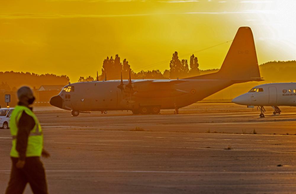 Military personnel walk by Belgian military planes, used as part of an evacuation from Afghanistan, upon arrival at Melsbroek Military Airport in Melsbroek, Belgium, Friday, Aug. 27, 2021. (AP Photo/Olivier Matthys)