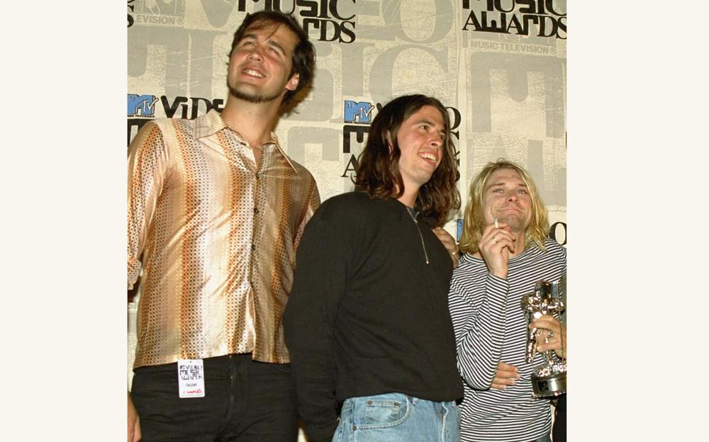 FILE - Nirvana band members Krist Novoselic, from left, Dave Grohl and Kurt Cobain pose after receiving the award for best alternative video for "In Bloom" at the 10th annual MTV Video Music Awards on Sept. 2, 1993, in Universal City, Calif. A 30-year-old man who appeared nude at 4 months old in 1991 on the cover of Nirvana's "Nevermind" album is suing the band and others, alleging the image is child pornography they have profited from. The suit, filed by Spencer Elden on Tuesday, Aug 24, 2021, seeks at least $150,000 from each of more than a dozen defendants, including the Kurt Cobain estate, surviving Nirvana members Novocelic and Grohl and Geffen Records. (AP Photo/Mark J. Terrill, File)