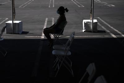 ARCHIVO - En esta imagen de archivo del 28 de agosto de 2021, una mujer en una zona de espera tras recibir una vacuna contra el COVID-19 en una clínica instalada en el estacionamiento de CalOptima en Orange, California. (AP Foto/Jae C. Hong, Archivo)