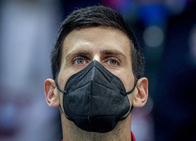 ARCHIVO - El serbio Novak Djokovic usa una máscara facial mientras escucha los himnos nacionales antes de un partido del grupo F de la Copa Davis entre Serbia y Austria en Innsbruck, Austria, el viernes 26 de noviembre de 2021. Novak Djokovic dice que no podrá competir en los próximos torneos de tenis en Indian Wells, California y Miami porque no está vacunado y no puede viajar a los Estados Unidos, el miércoles 9 de marzo de 2022. (Foto/Michael Probst, Archivo)