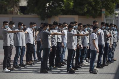Alumnos palestinos de secundaria con mascarilla en una escuela de Ciudad de Gaza, el miércoles 1 de septiembre de 2021. Las autoridades palestinas de salud lanzaron una campaña de vacunación para alumnos entre 16 y 18 años en las escuelas secundarias de la Franja de Gaza, en medio de un repunte de contagios de coronavirus. (AP Foto/Khalil Hamra)