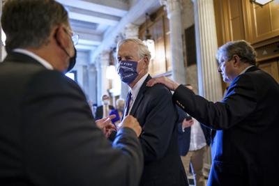 El senador independiente Angus King, al centro, habla con su colega demócrata Gary Peters, izquierda, mientras el republicano John Kennedy pasa junto a ellos el viernes, 30 de julio del 2021, en el Capitolio, en Washington. (AP Foto/J. Scott Applewhite)
