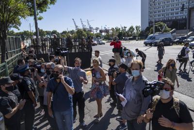 Periodistas esperan afuera de la corte federal después de que el presidente argentino, Alberto Fernández, ingresara en automóvil en Buenos Aires, Argentina, el martes 15 de febrero de 2022. (AP Foto/Rodrigo Abd)