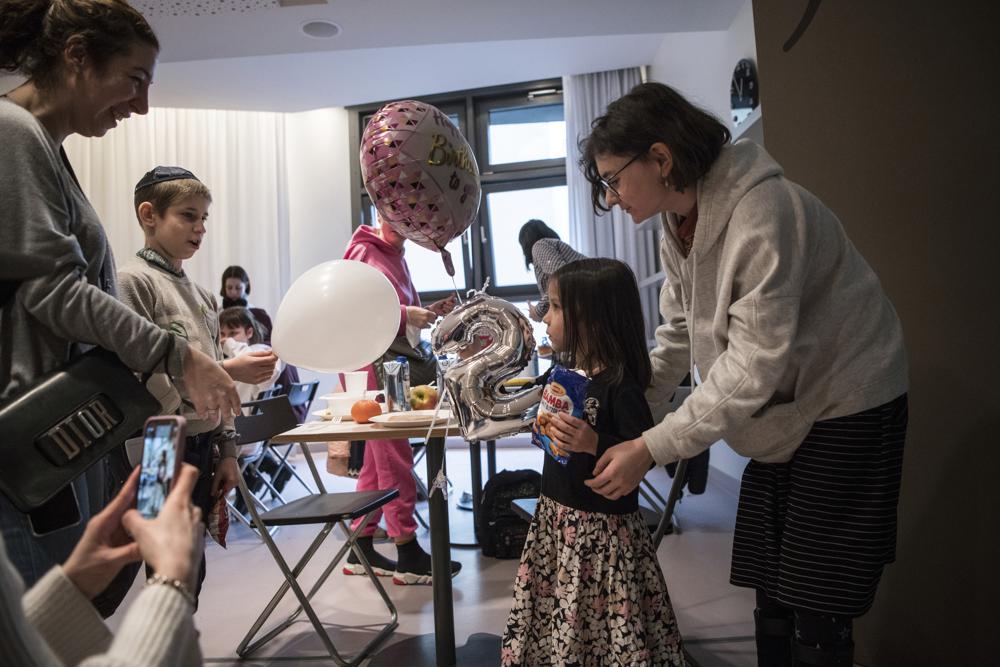 Sada, druga od prawej, dostaje balon w dniu swoich urodzin po tym, jak przybyła z sierocińca w Odessie na Ukrainie, w hotelu w Berlinie, piątek, 4 marca 2022 r. Ponad 100 żydowskich dzieci uchodźców, które zostały ewakuowane z domu opieki zastępczej na rozdartej wojną Ukrainie i przejechały autobusem przez Europę, przybyło do Berlina. (AP Photo/Steffi Loos)
