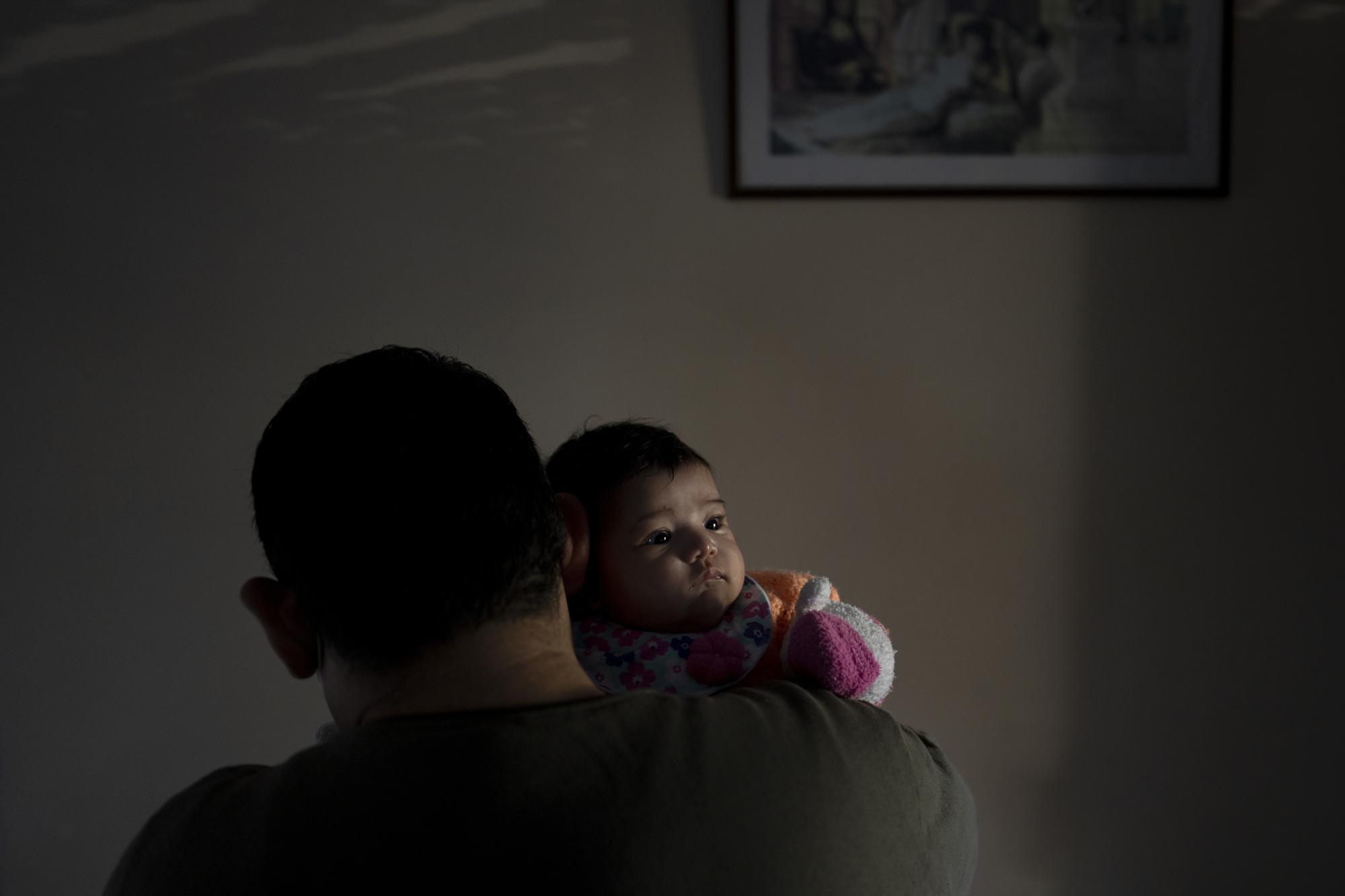 Diego Roman holds his daughter, Victoria Soto, for a photo in Lomas de Zamora, Argentina, Sunday, July 4, 2021. Victoria was born on April, 13, 2021, and her mother, Elizabeth Soto, died from COVID-19 days later. (AP Photo/Natacha Pisarenko)