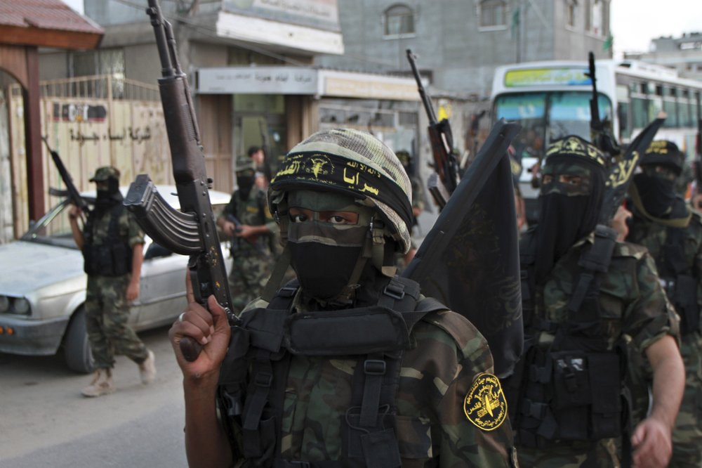 FILE - In this Oct. 2, 2012 file photo, masked militants of the Islamic Jihad group march during a rally marking the 17th anniversary of the death of the group's leader Fathi Shekaki, in Rafah Refugee camp in the southern Gaza Strip. The group was founded in 1981 with the aim of establishing an Islamic Palestinian state in the West Bank, Gaza and all of what is now Israel. It is designated a terrorist organization by the U.S. State Department, European Union and other governments. (AP Photo/Adel Hana, File)