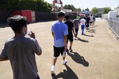 ARCHIVO - En este imagen de archivo del 2 de julio de 2021, niños caminando juntos tras un partido de ´fútbol en un centro de emergencia para niños migrantes en Pomona, California. Cinco meses después de que el gobierno de Biden declarase una emergencia y se apresurase a habilitar refugios para alojar a una cifra récord de menores que cruzaban solos la frontera entre México y Estados Unidos, los niños seguían haciendo largas estancias en los centros mientras continuaban las llegadas, según activistas de bienestar infantil. (AP Foto/Marcio Jose Sanchez, Pool, Archivo)