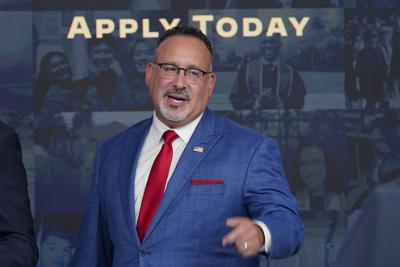El secretario de Educación, Miguel Cardona, responde preguntas con el presidente Joe Biden al salir de un evento sobre el alivio de la deuda estudiantil en el Auditorio South Court en el complejo de la Casa Blanca en Washington, el 17 de octubre de 2022. Cardona ha dado positivo por COVID-19, dice el Departamento de Educación el 1 de noviembre de 2022. (AP Photo/Susan Walsh, Archivo)