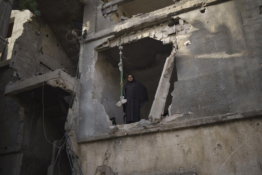 Jawaher Nassir mira desde una habitación de su casa, muy dañada por los ataques aéreos en la guerra de 11 días entre Israel y Hamas, el grupo armado que controla Gaza, el viernes 11 de junio de 2021 en Beit Hanoun, en el norte de la Franja de Gaza. "Nuestros recuerdos están aquí", dijo. (AP Foto/Felipe Dana)
